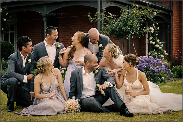 The bridal party enjoys a drink and some laughter with the newlyweds in front of McCormick House at Willow Creek Winery in Merricks North, Victoria.